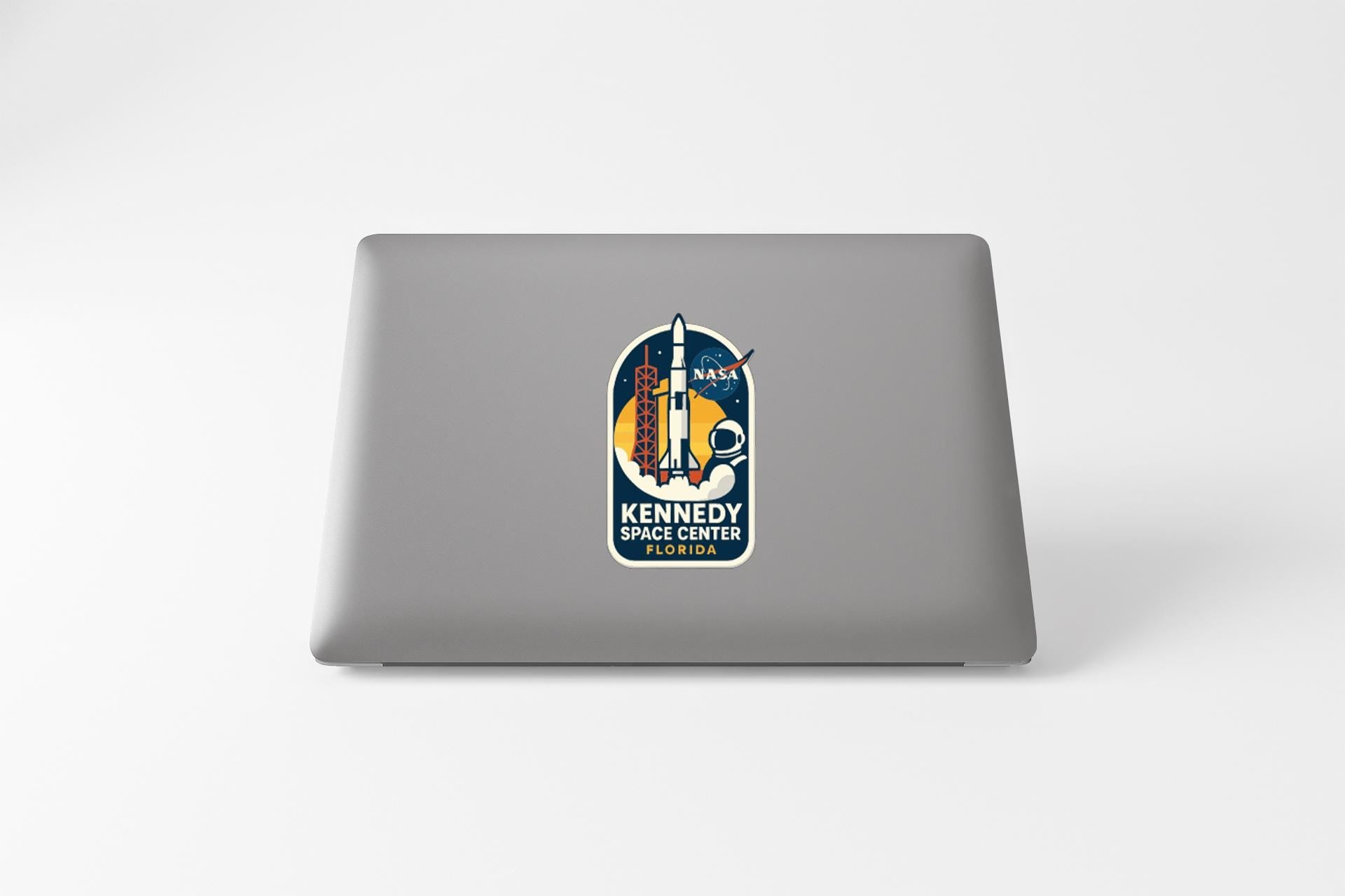 A sticker on the back of a laptop, featuring an illustration of a rocket and the text "KENNEDY SPACE CENTER"