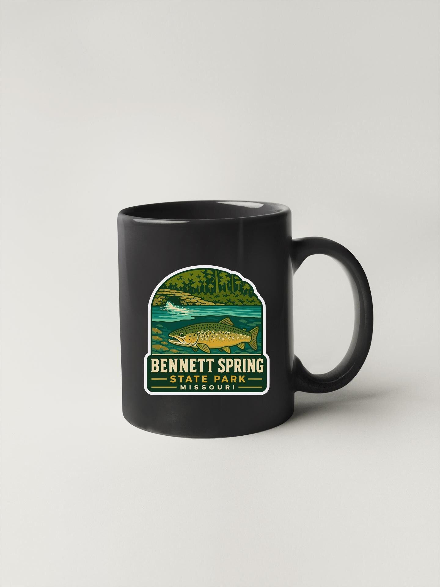 A black coffee mug with a graphic design featuring a fish and the text "Bennett Spring State Park Missouri".