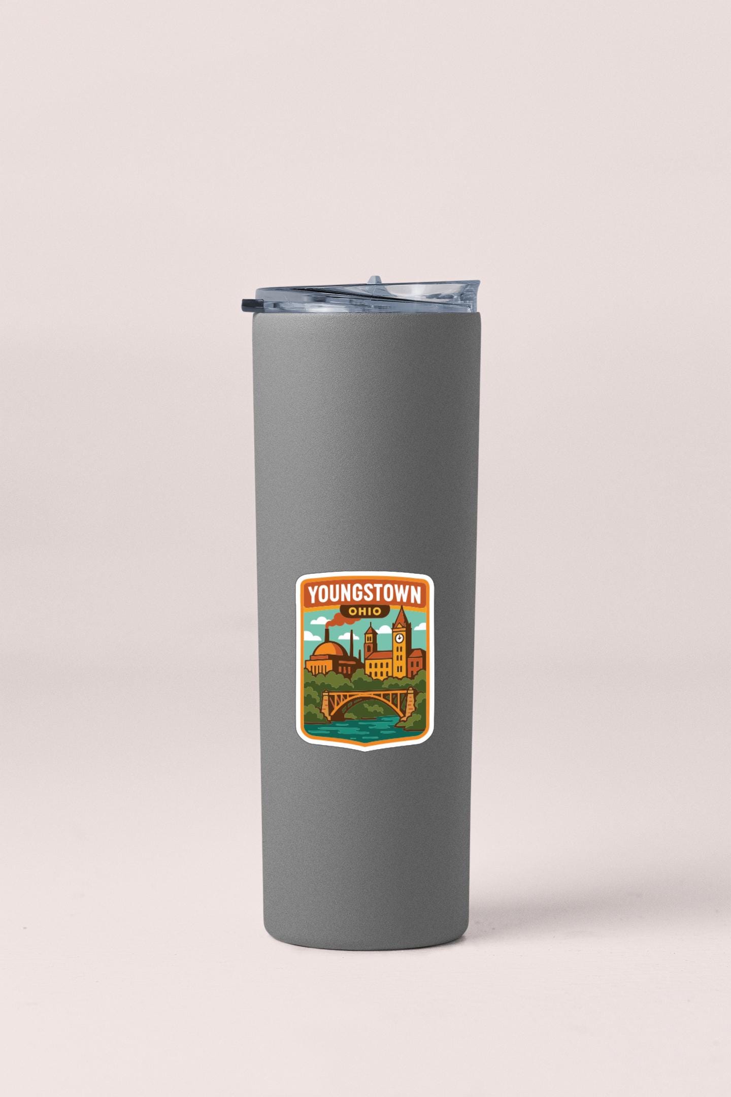 A gray insulated tumbler with a sticker depicting a cityscape and the text "YOUNGSTOWN, OHIO" printed on it.