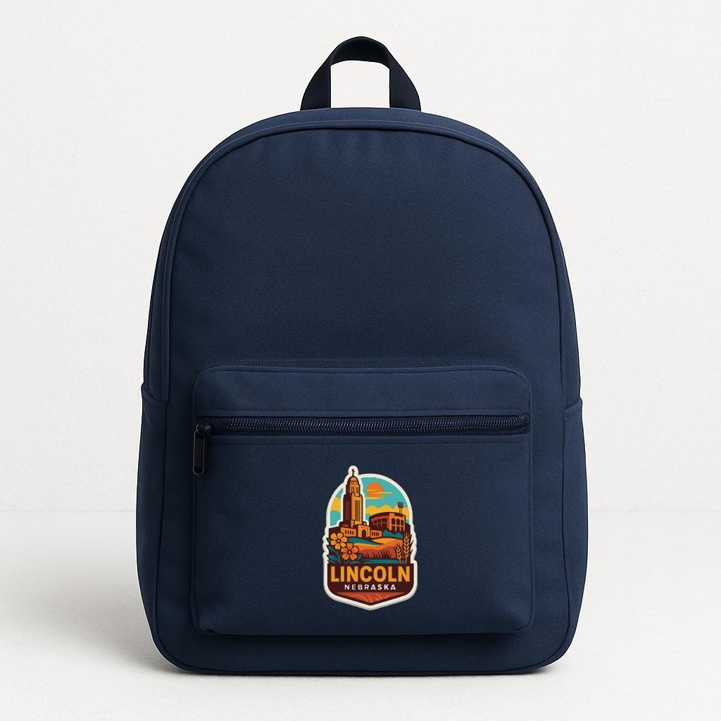 A navy blue backpack with a prominent Lincoln, Nebraska logo on the front pocket.