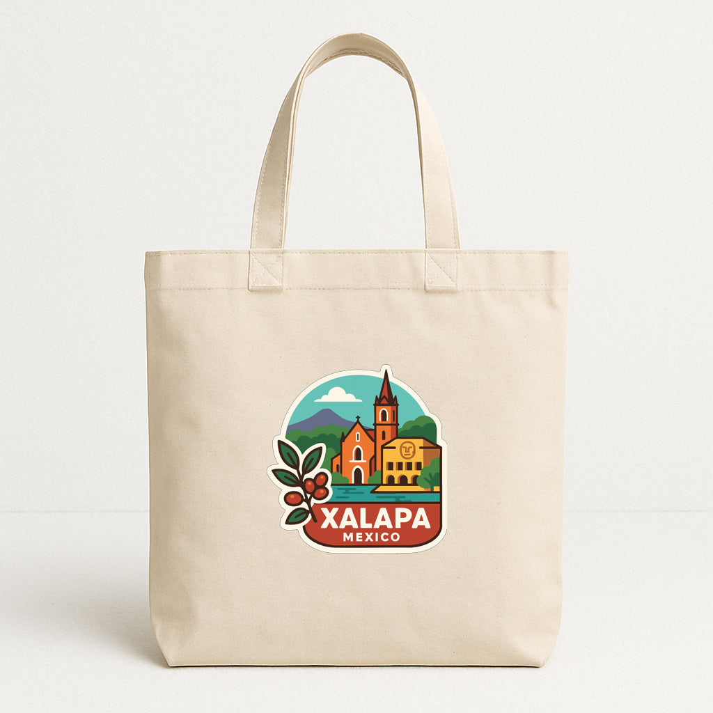 A beige tote bag with a graphic design depicting a landmark in Mexico, specifically the town of Xalapa.