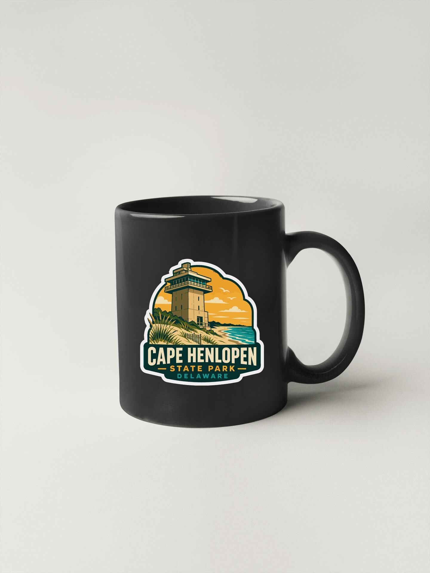 A black coffee mug with a graphic design depicting Cape Henlopen State Park.