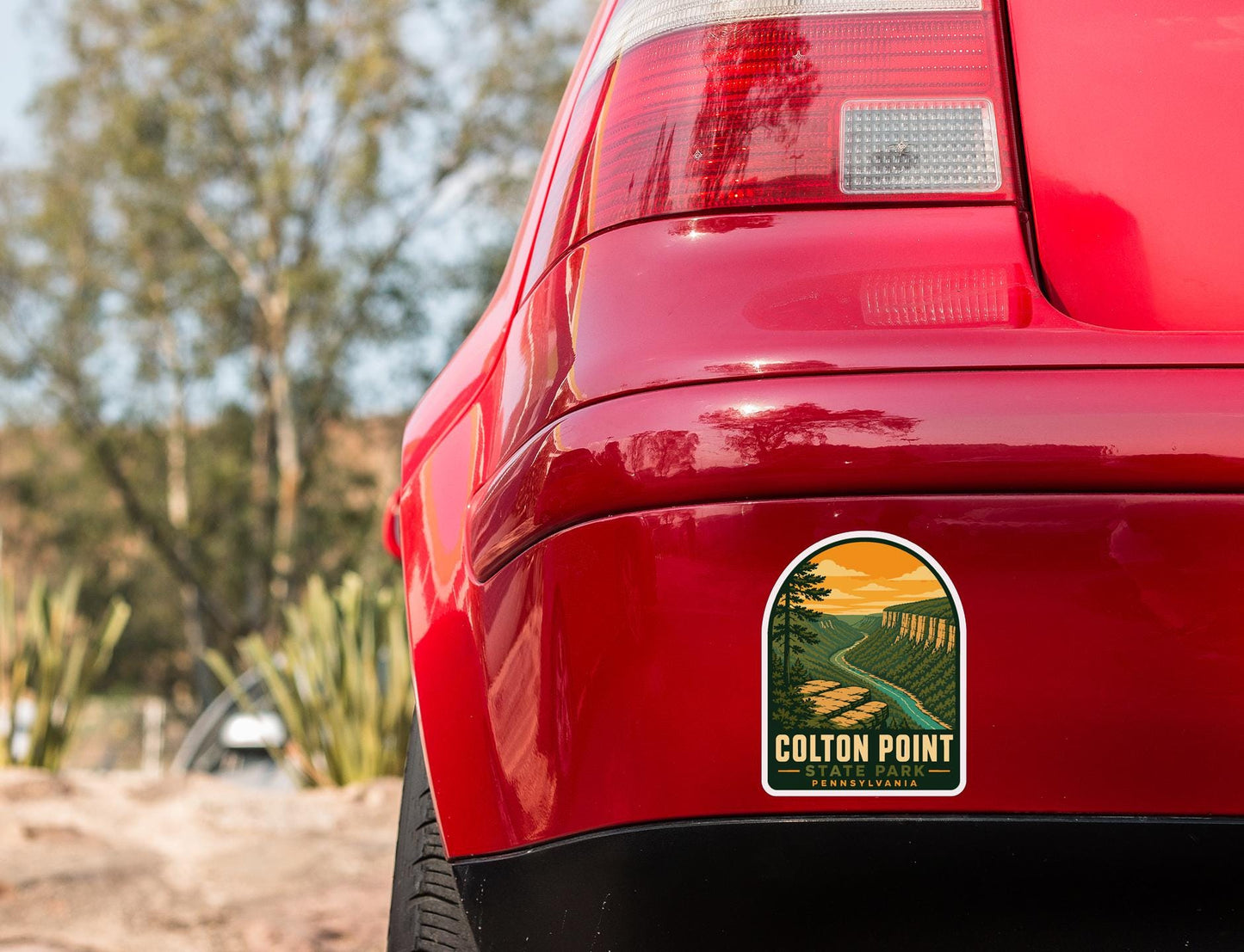 the rear end of a red car with a sticker on the back window that says "COLTON POINT PENNSYLVANIA".