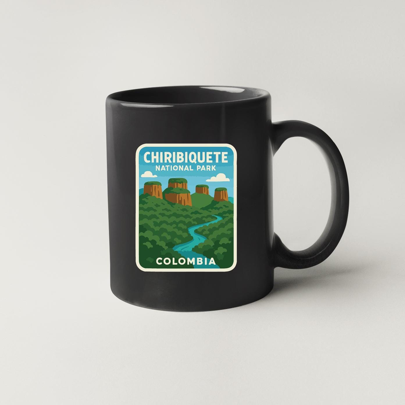 A black coffee mug with a graphic design depicting the Chiribiquete National Park in Colombia.