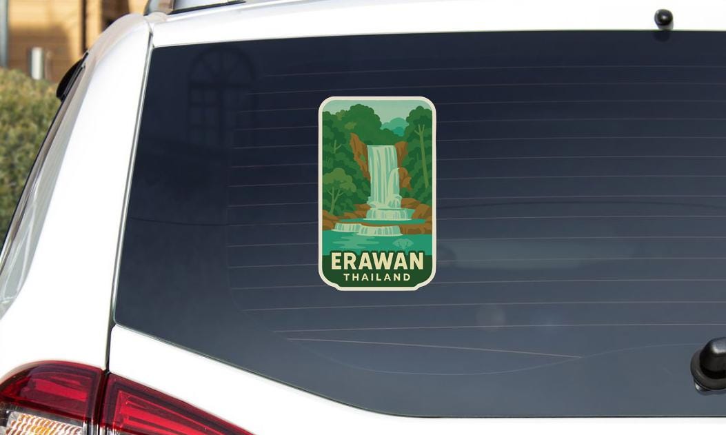 A sticker on the rear window of a car, depicting a waterfall in a tropical setting.
